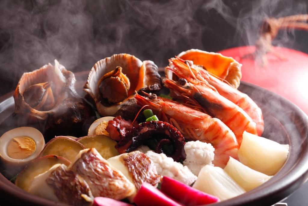 un bol de nourriture avec de la viande et des légumes sur une table dans l'établissement Awaji Hamarikyu, à Minamiawaji
