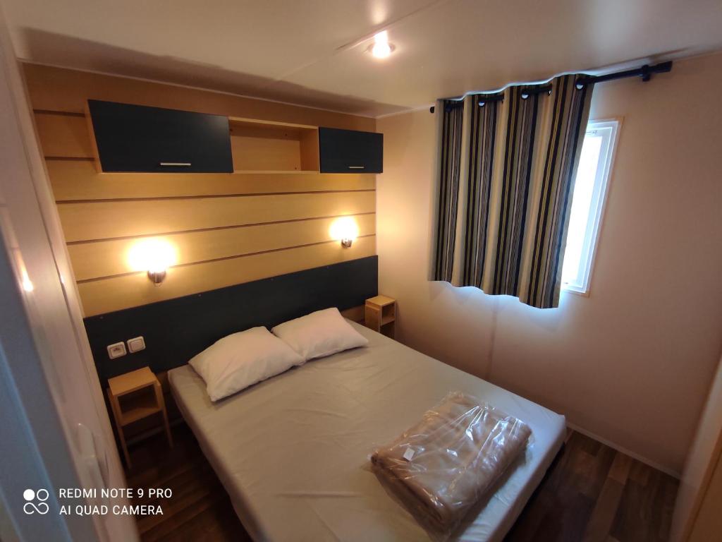 une petite pièce avec un lit et une fenêtre dans l'établissement Mobil home 5-6 personnes - climatisé, à Port-la-Nouvelle