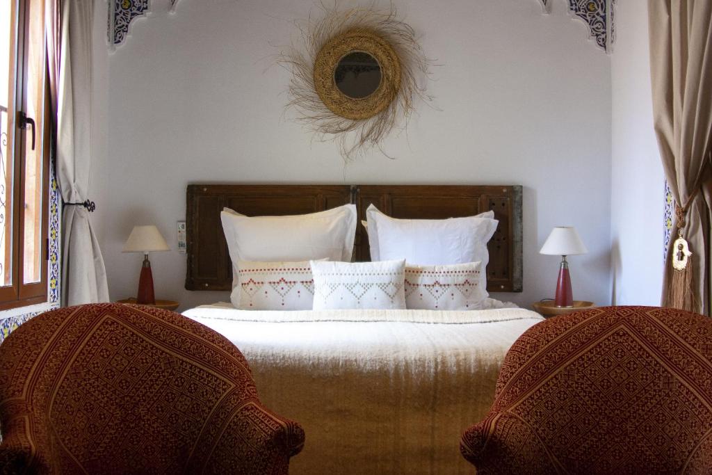 - une chambre avec un lit, deux chaises et un miroir dans l'établissement Dar El Bali, à Fès