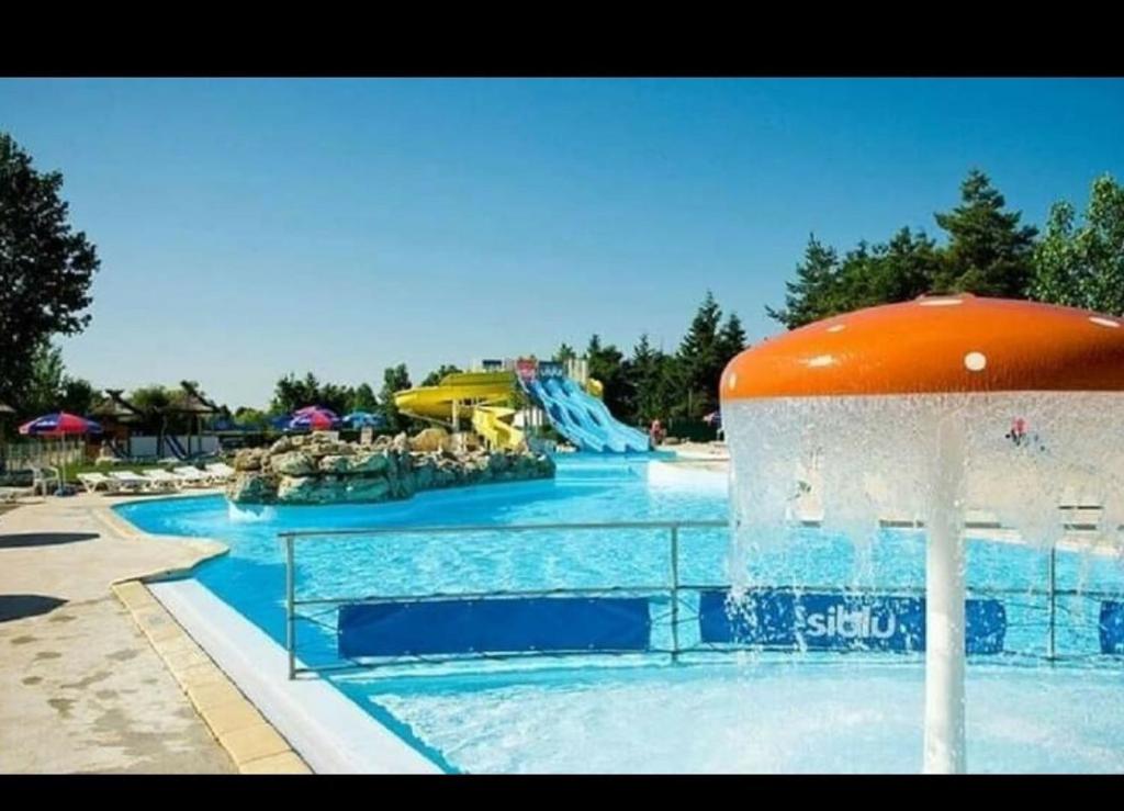 une piscine avec un toboggan aquatique dans un complexe hôtelier dans l'établissement Assist' Mobil Home 289 - Mobil Home élégance 2 chambres 6 personnes, à Onzain 2 autres photos