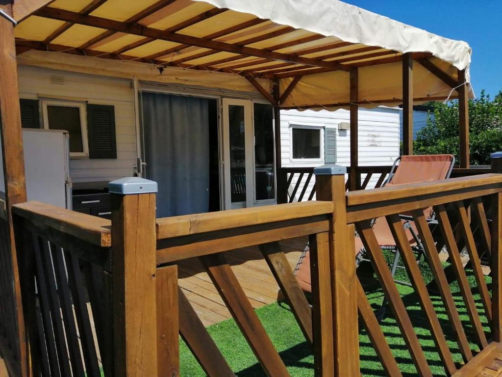 - une terrasse en bois avec un parasol dans l'établissement vacances familiales dans camping avec piscine, à Fréjus