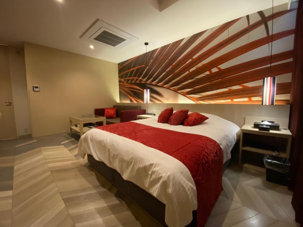 une chambre avec un grand lit dans une pièce dans l'établissement ルトゥール姫路 Retur HIMEJI 男塾ホテルグループ, à Himeji