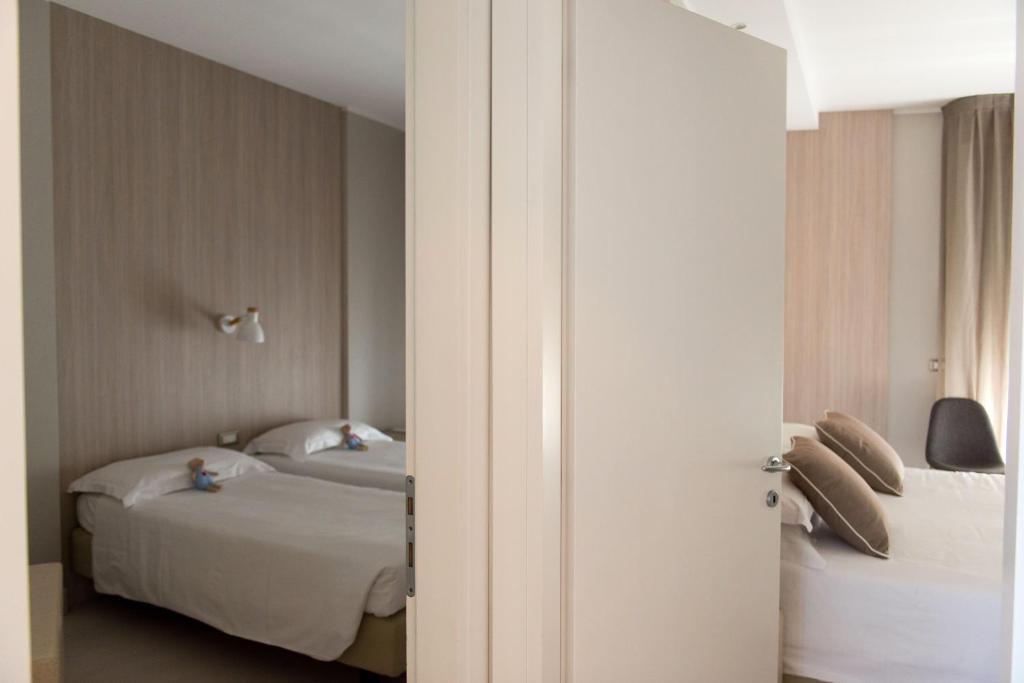 une chambre avec deux lits et une porte ouverte dans l'établissement Hotel Delle Nazioni, à Lido di Jesolo 50 autres photos