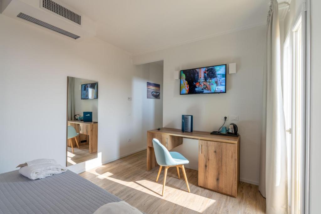 - une chambre avec un bureau, un lit et une chaise dans l'établissement Hotel Mondial, à Lido di Jesolo