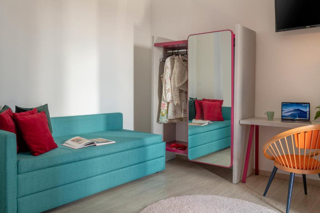 un salon avec un canapé bleu et un miroir dans l'établissement Hotel Rainbow ***S, à Rimini