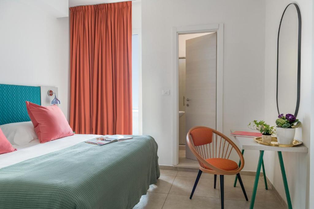 une chambre avec un lit, une table et une chaise dans l'établissement Hotel Rainbow ***S, à Rimini
