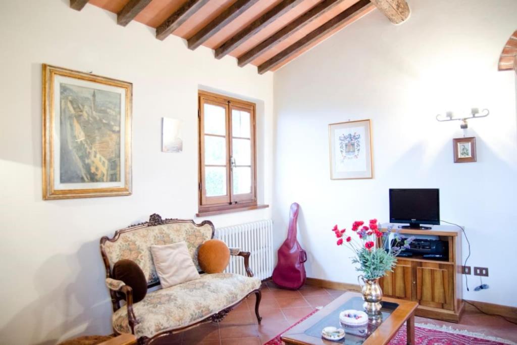 un salon avec un canapé et une télévision dans l'établissement Podere Belvedere - Villa with private swimming-pool, à Carmignano