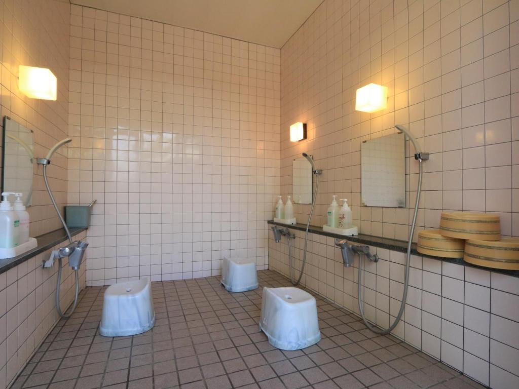 La salle de bains est pourvue de 2 toilettes et de 2 lavabos. dans l'établissement Minshuku Miyama, à Yamanouchi 37 autres photos