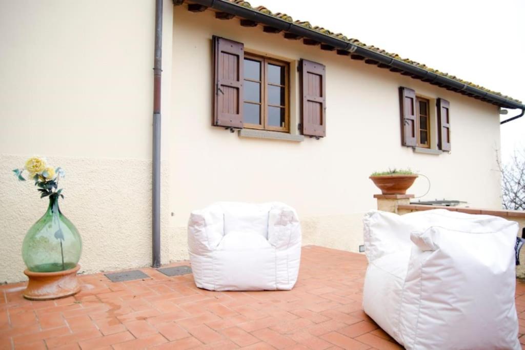 deux chaises blanches et un vase sur une terrasse dans l'établissement Podere Belvedere - Villa with private swimming-pool, à Carmignano