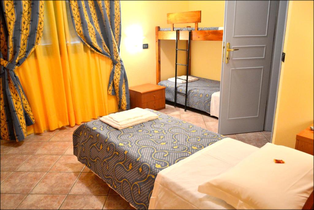 Cette petite chambre comprend 2 lits et une porte. dans l'établissement Hotel Anfora, à Capoliveri