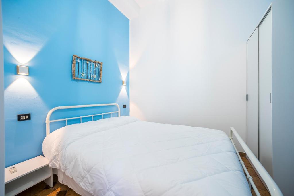 - une chambre bleue avec un lit et un mur bleu dans l'établissement Ahm7nani, à Mascali
