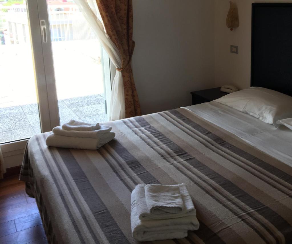 une chambre avec un lit avec deux serviettes dessus dans l'établissement Hotel Consul - Family Hotel, à Riccione