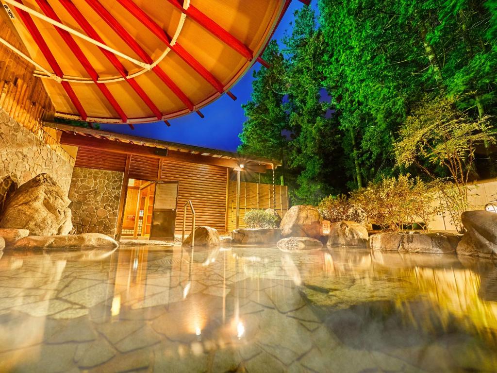 une terrasse avec un parasol et une fontaine dans l'établissement Ooedo Onsen Monogatari Gero Bekkan, à Gero