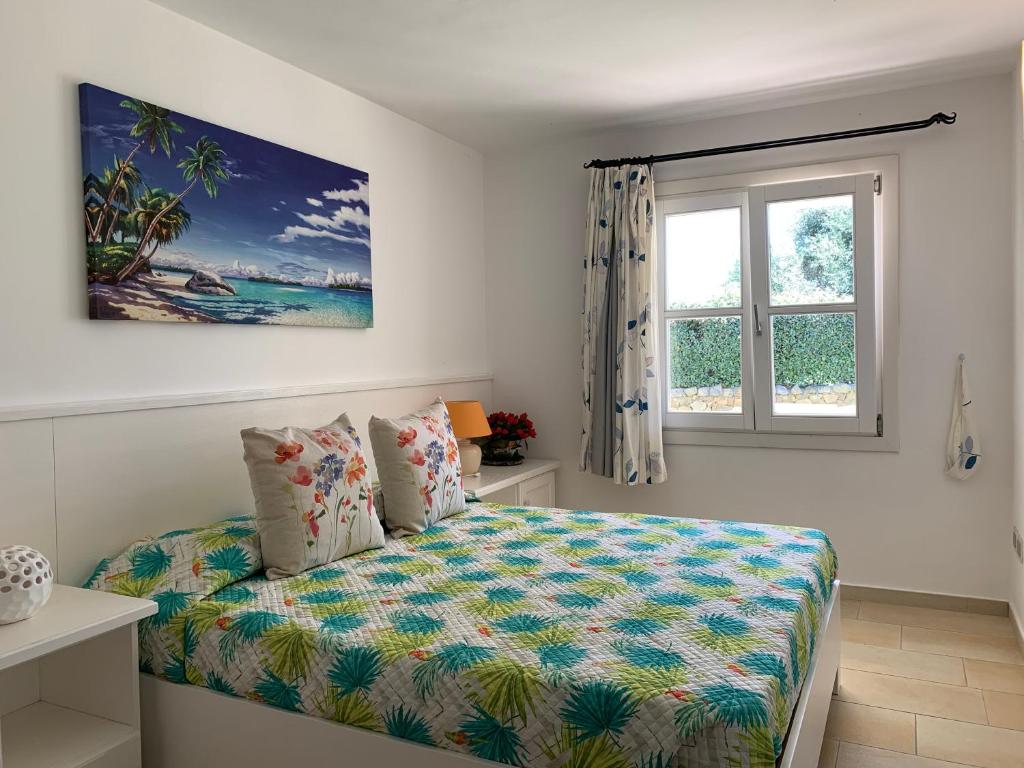 une chambre avec un lit et une fenêtre dans l'établissement VillaLuxx, à Porto San Paolo