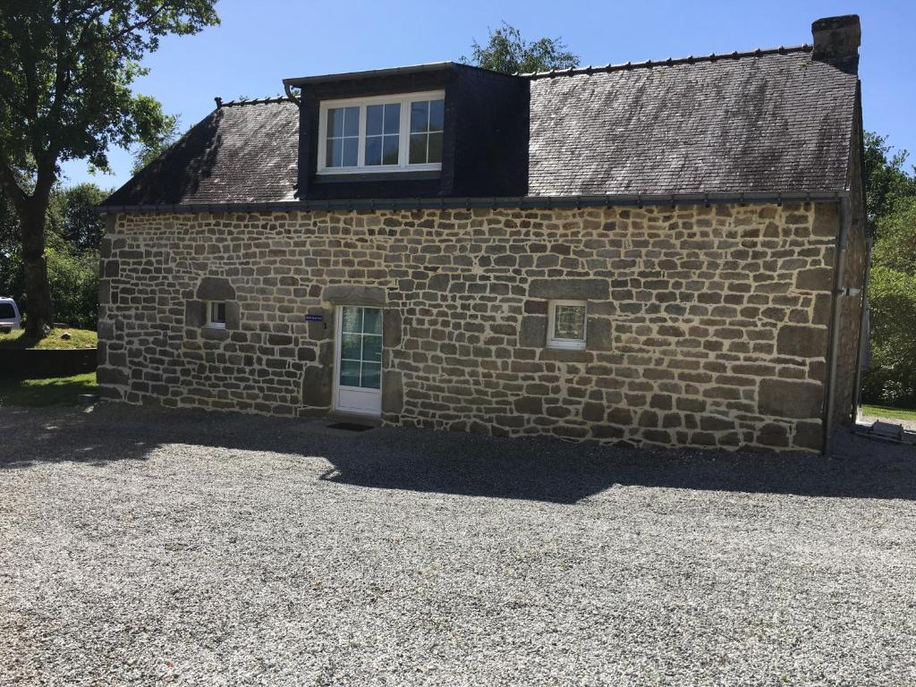 une maison en pierre avec une fenêtre sur le côté de celle-ci dans l'établissement Gites de Kermoel, Belle Île, à Kernascléden