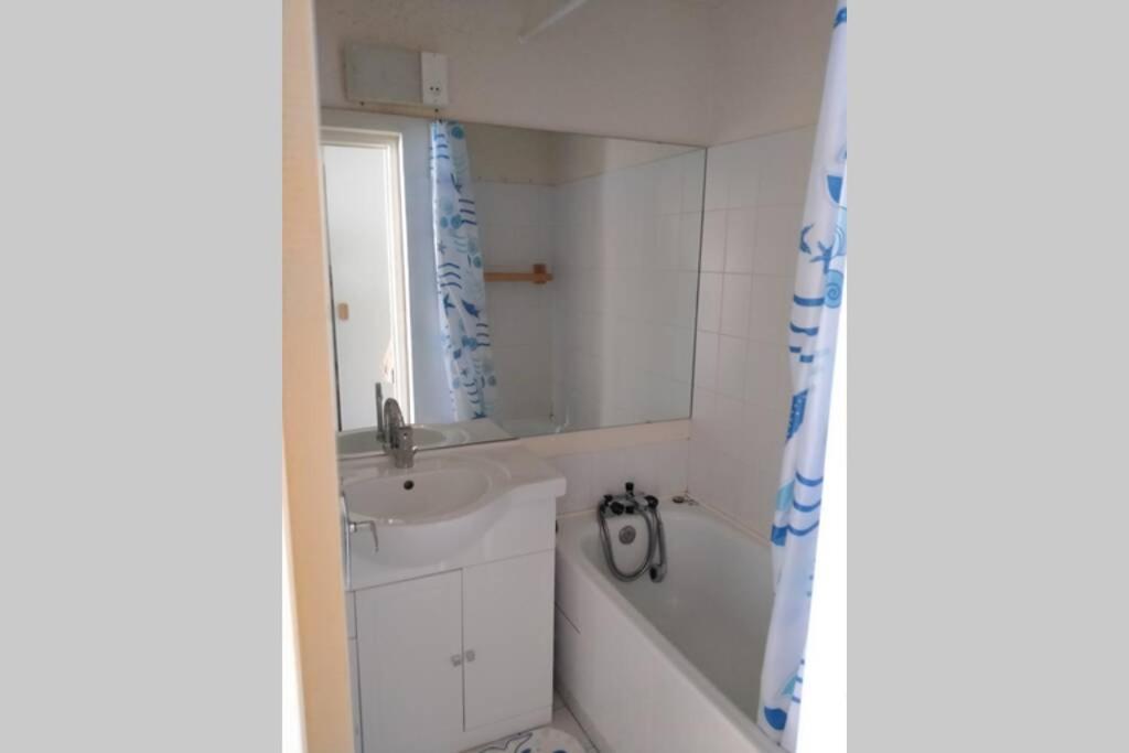 La salle de bains est pourvue d'une baignoire blanche, d'un lavabo et d'une baignoire. dans l'établissement Studio 4pers vue piste, au Corbier