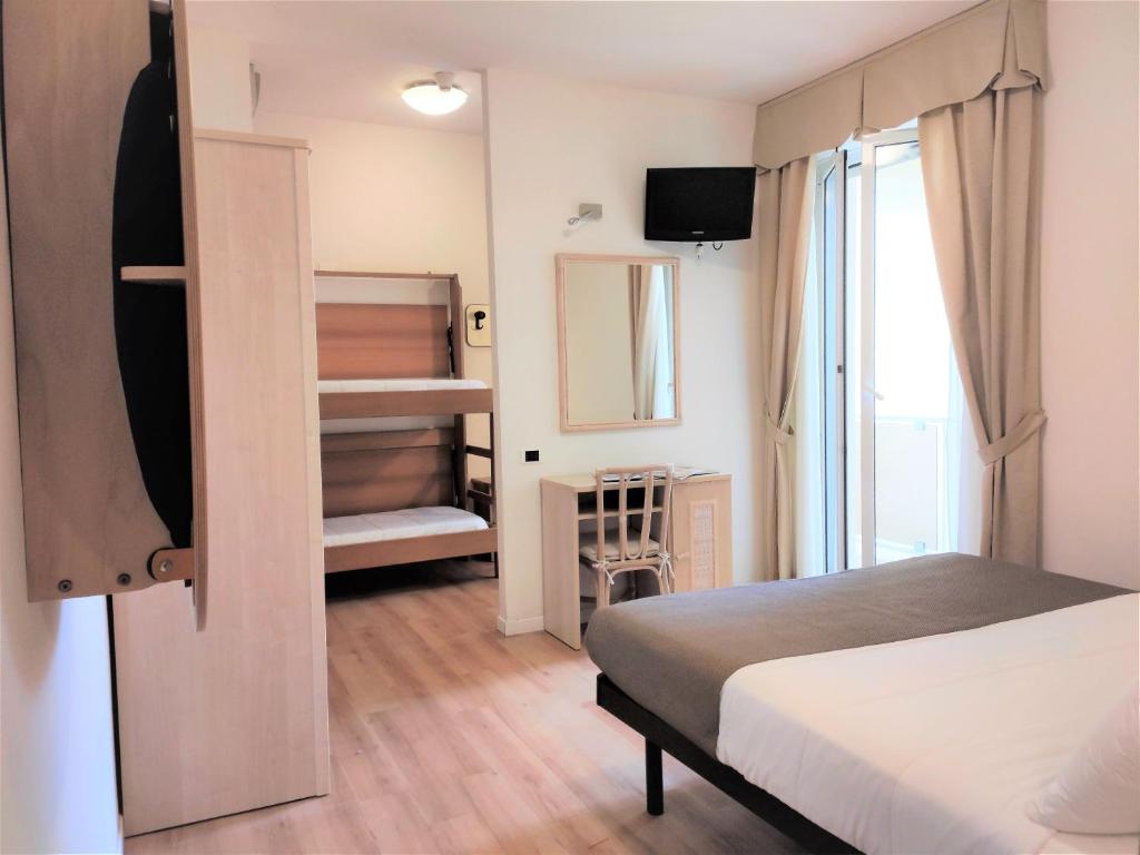 une petite chambre avec un lit et une fenêtre dans l'établissement Pinetina Mare Baby Family Hotel, à Cervia