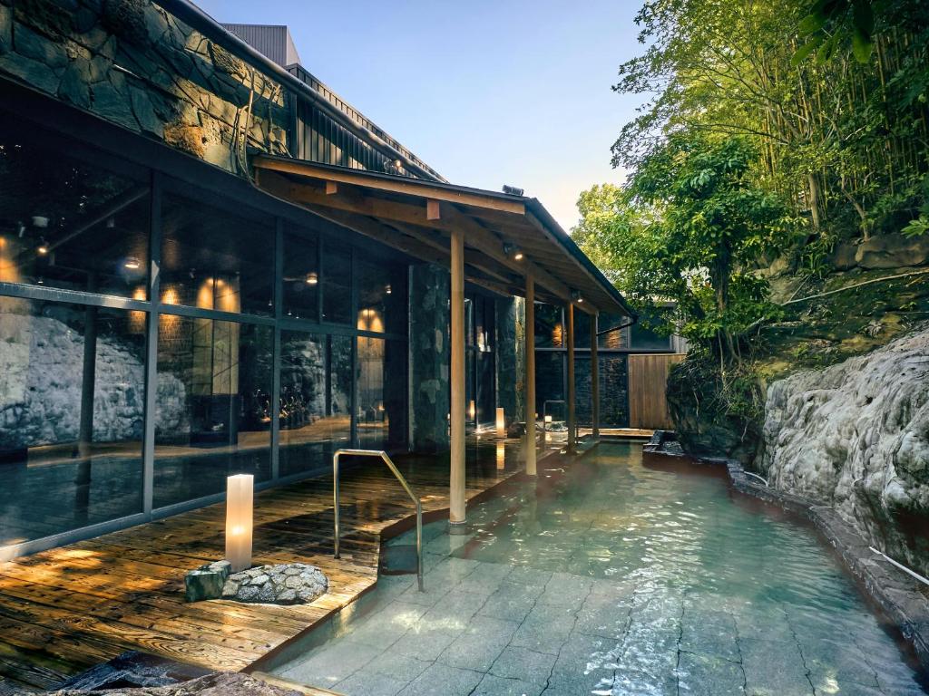 une maison avec une piscine d'eau à côté d'un bâtiment dans l'établissement Ooedo Onsen Monogatari Premium Shirahama Gyoen, à Shirahama