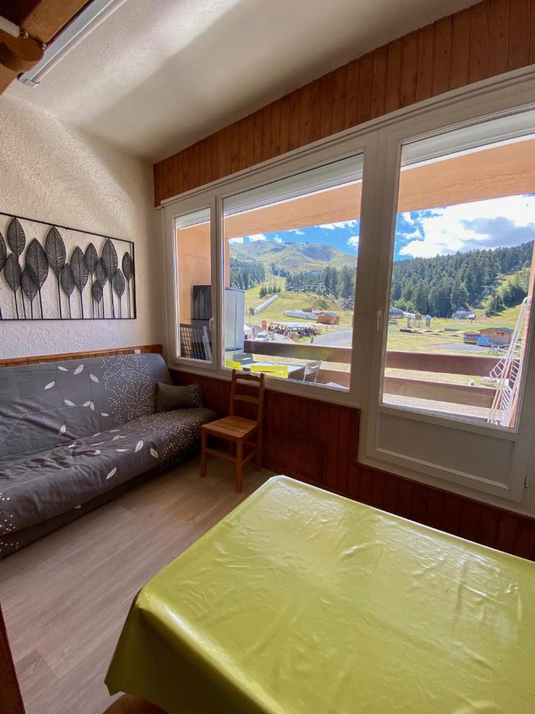 une chambre avec un lit et une grande fenêtre dans l'établissement SUPER LIORAN - APPARTEMENT ENTIÈREMENT ÉQUIPÉ, à Laveissière