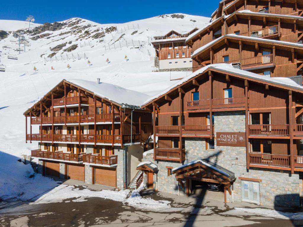 un lodge de ski dans la neige en face d'une montagne dans l'établissement Chalet des Neiges Plein Sud, à Val Thorens