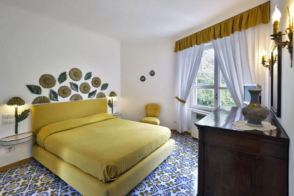 une chambre avec un lit jaune et une fenêtre dans l'établissement Villa Felicita, à Massa Lubrense