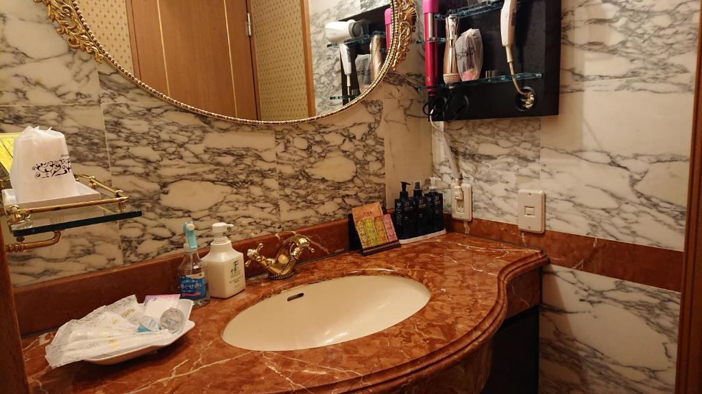 une salle de bain avec un lavabo et un miroir dans l'établissement Hotel Zips (Adult Only), à Kawaguchi