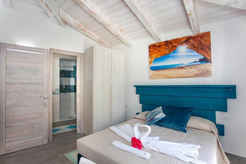 une chambre avec un lit avec une tête de lit bleue dans l'établissement Villa Elisir Luxury - Le Residenze del Mare, à Porto San Paolo