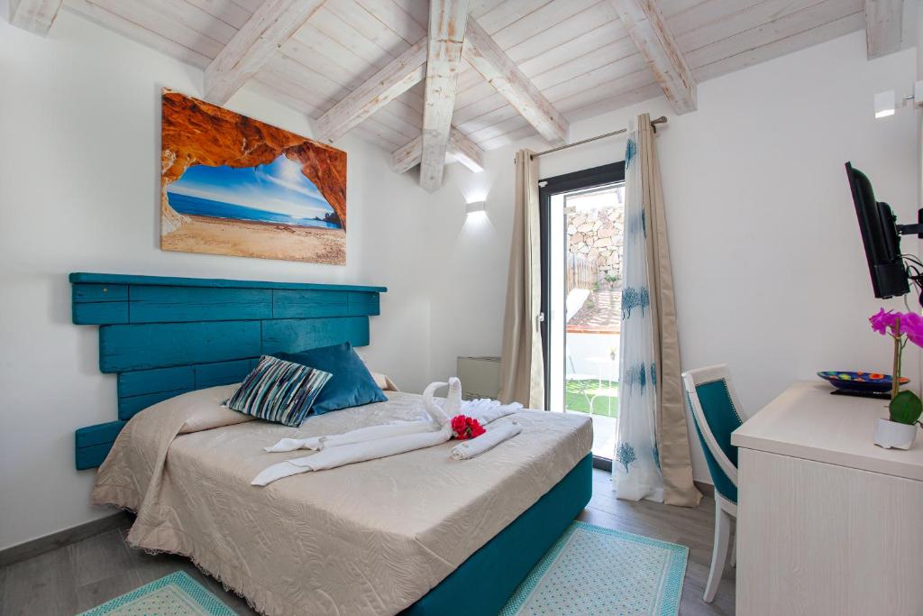 - une chambre avec un lit doté d'une tête de lit bleue et d'une fenêtre dans l'établissement Villa Elisir Luxury - Le Residenze del Mare, à Porto San Paolo 36 autres photos