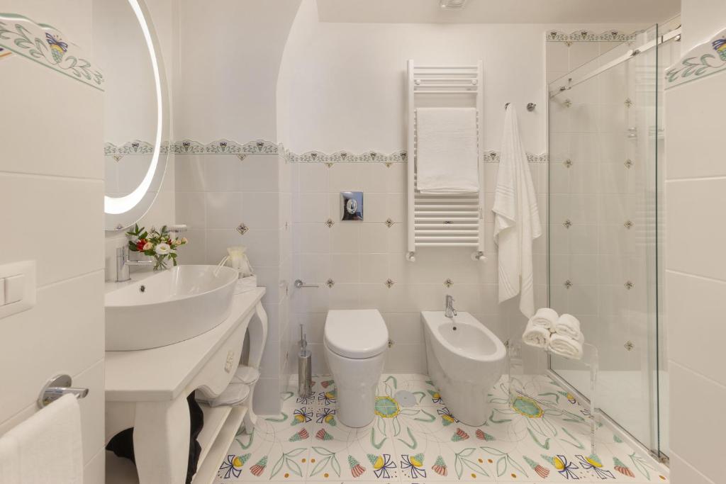 une salle de bain blanche avec toilettes et lavabo dans l'établissement Antica Rheginna Luxury Room, à Minori 30 autres photos