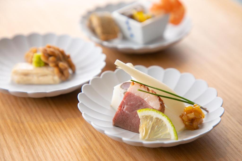 trois plaques alimentaires sur une table en bois dans l'établissement Yufuin Bath Satoyamasafu, à Yufu