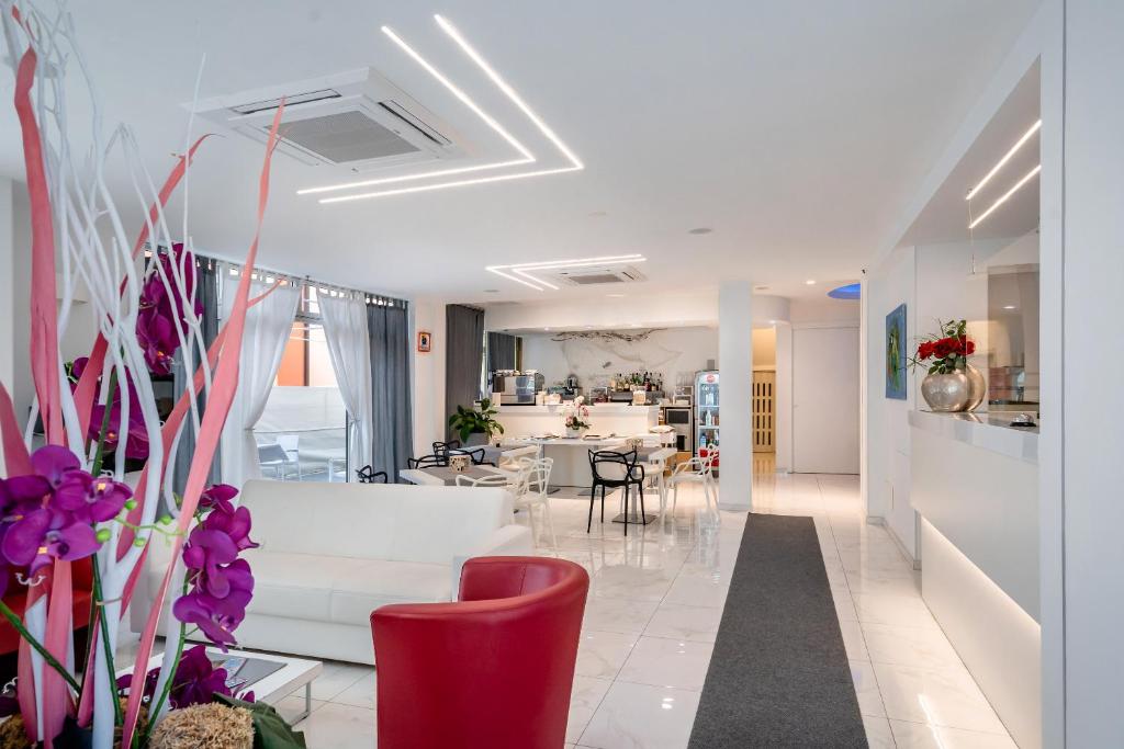 un salon avec un canapé blanc et une cuisine dans l'établissement Hotel Tre Rose, à Caorle