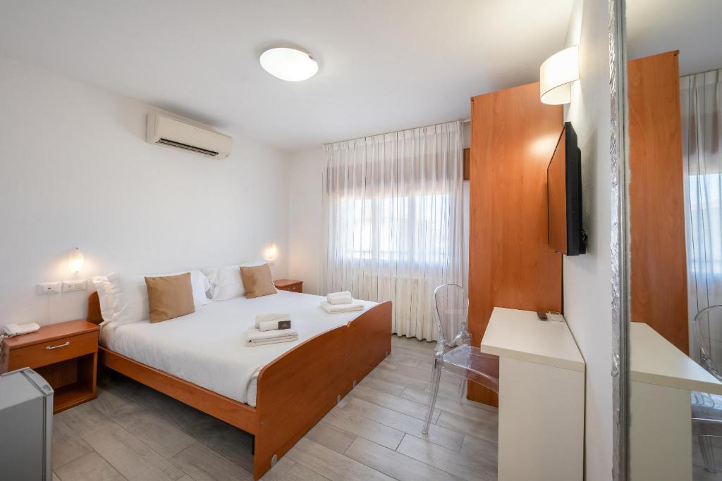une chambre d'hôtel avec un lit et une télévision dans l'établissement Hotel Tre Rose, à Caorle