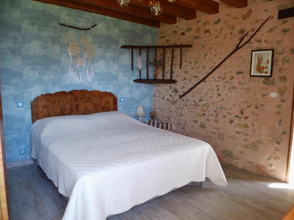 une chambre avec un lit blanc dans une pièce dans l'établissement GITE DU HOUSSAY, à Valennes