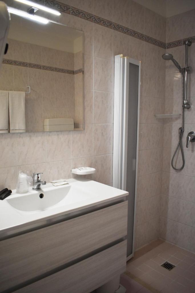 une salle de bain avec un lavabo blanc et une douche dans l'établissement Hotel Edelweiss, à Lido di Jesolo