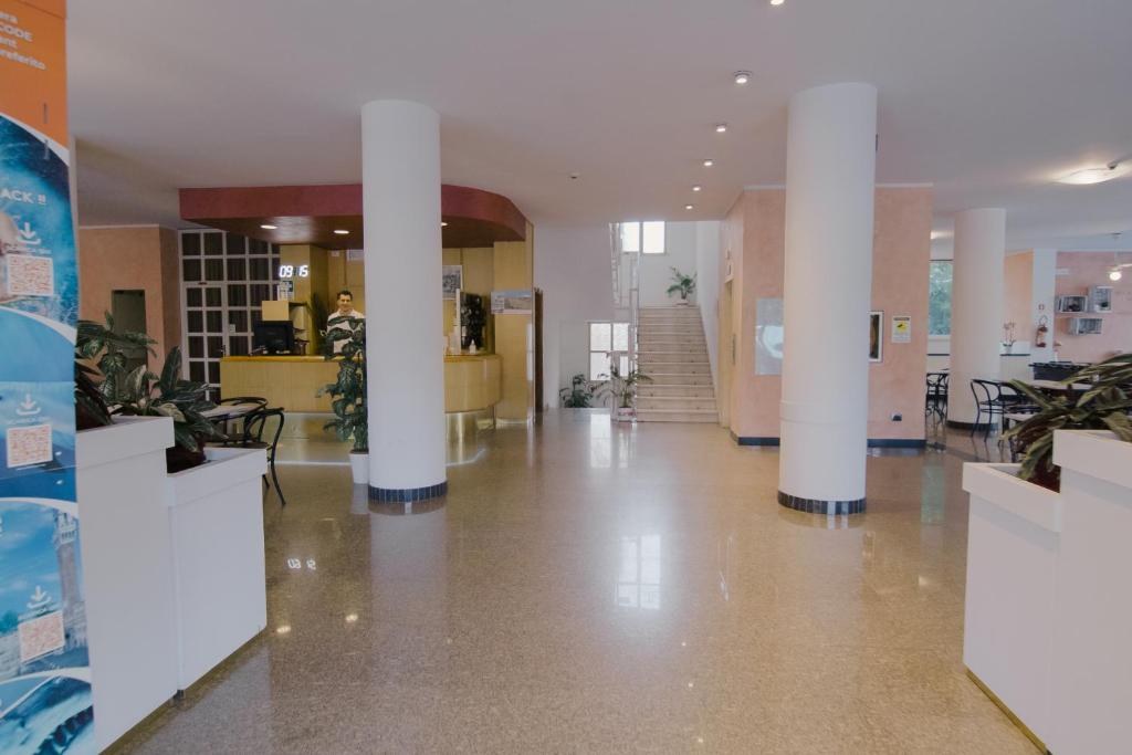 un hall avec colonnes et plantes dans un bâtiment dans l'établissement Hotel Beverly, à Rimini 99 autres photos