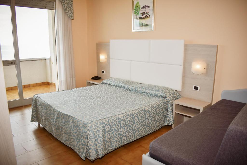 une chambre d'hôtel avec deux lits et une fenêtre dans l'établissement Hotel Costa Verde, à Tortoreto Lido