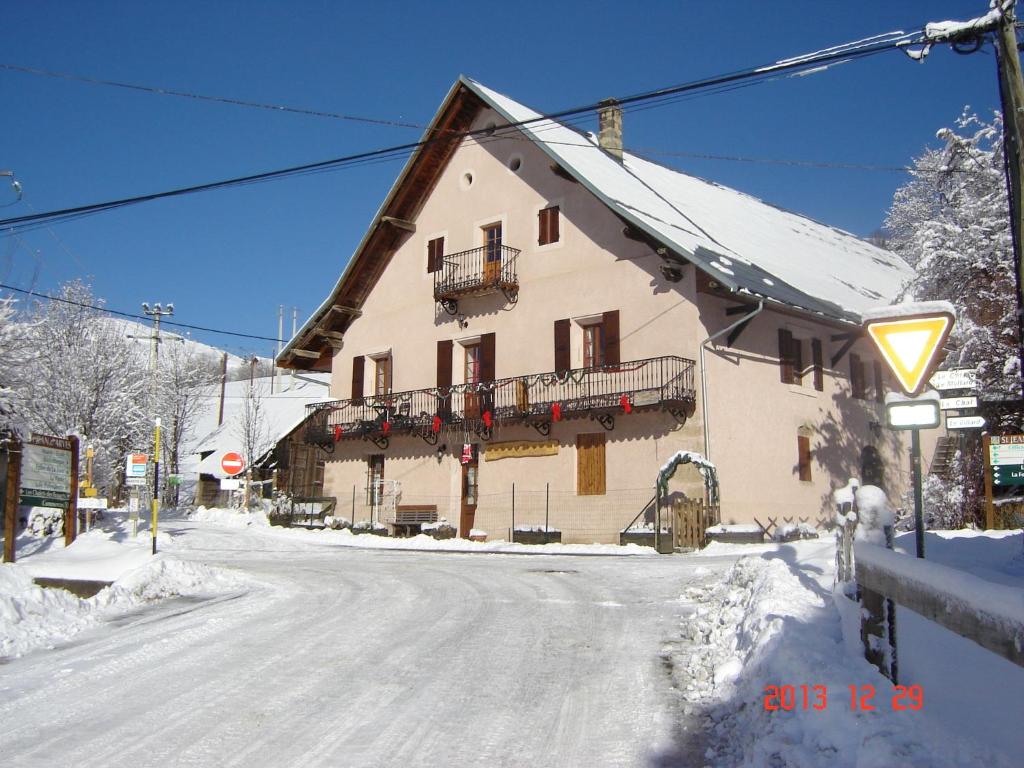 un bâtiment situé sur le côté d'une rue enneigée dans l'établissement appartement edlweiss 4 pers dans gite"la maison d'augustin" classé 3 étoiles, la tour,73530 st jean d'arves, à Saint-Jean-dʼArves