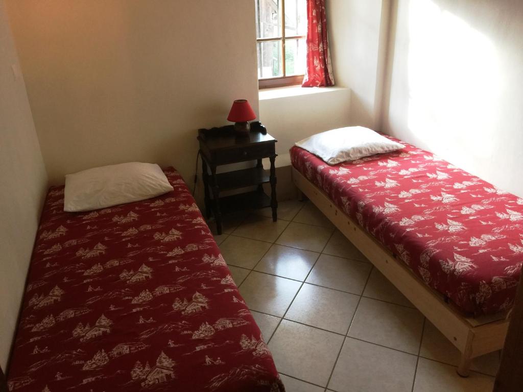 Cette petite chambre comprend un lit, une table et une fenêtre. dans l'établissement appartement edlweiss 4 pers dans gite"la maison d'augustin" classé 3 étoiles, la tour,73530 st jean d'arves, à Saint-Jean-dʼArves