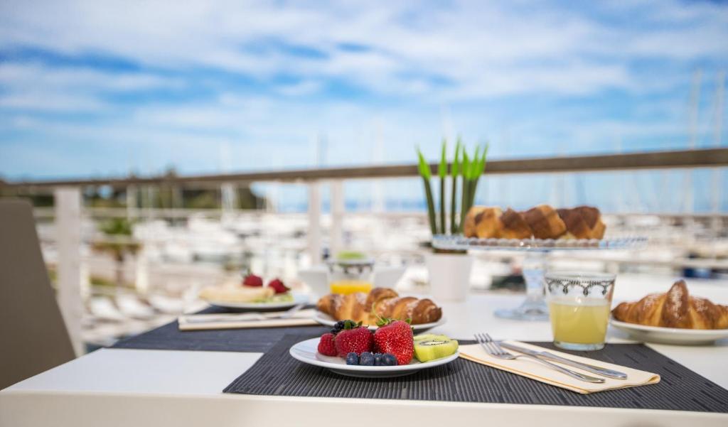 une table avec des assiettes de nourriture et une vue sur l'océan dans l'établissement Marina di Scarlino Resort, à Puntone di Scarlino