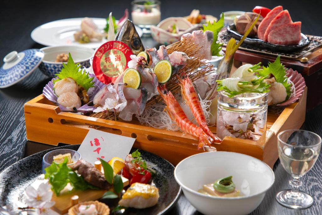 une table avec des assiettes de nourriture sur une table dans l'établissement Yufuin Hoteiya, à Yufu