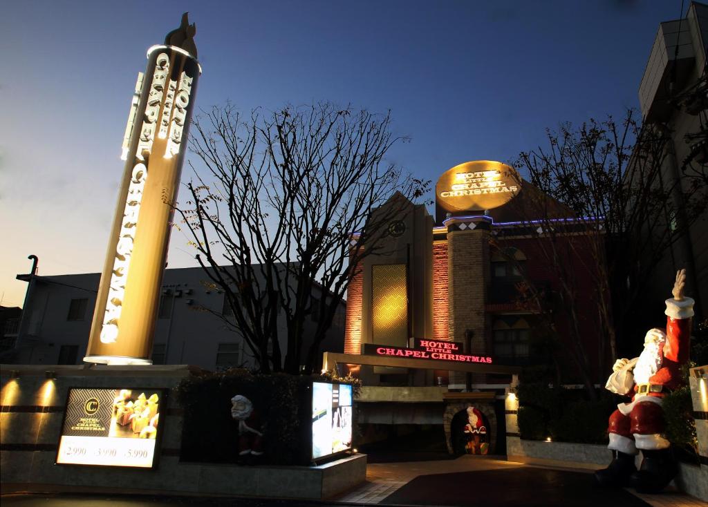 un bâtiment avec une enseigne devant lui avec des décorations de Noël dans l'établissement Fukuoka Little Chapel Christmas (Love Hotel), à Fukuoka