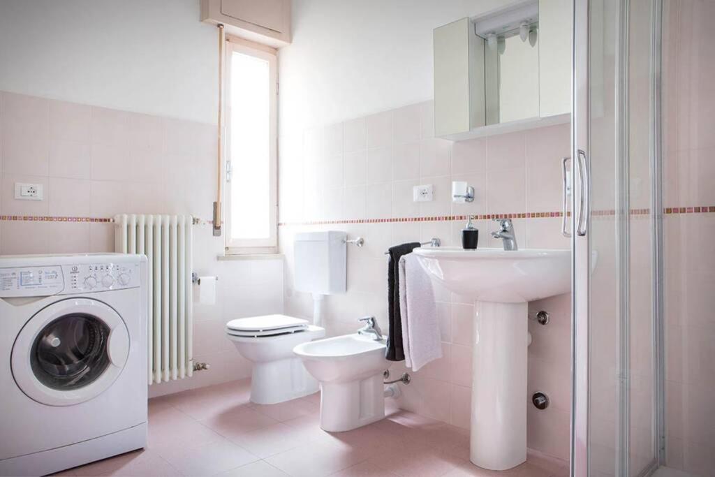 une salle de bain blanche avec une machine à laver et un lavabo dans l'établissement Villa Belvedere-Con piscina a Bardolino, à Costermano 26 autres photos