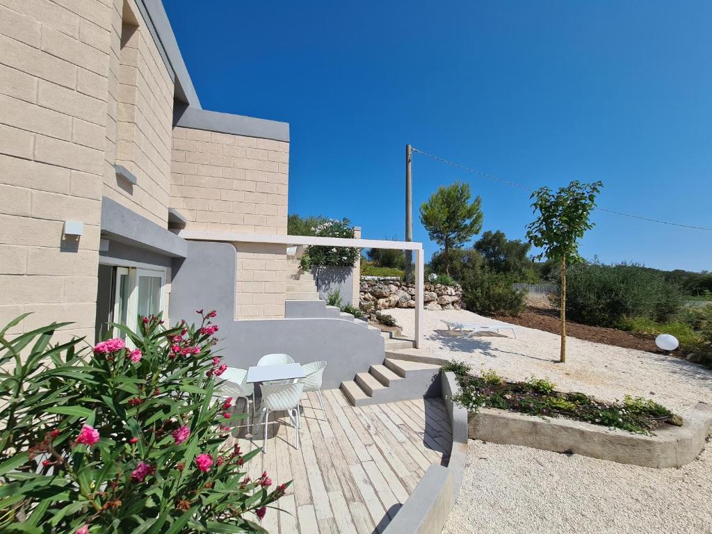un bâtiment avec une terrasse en bois avec des chaises et des fleurs dans l'établissement VILLA ROSA, à Peschici