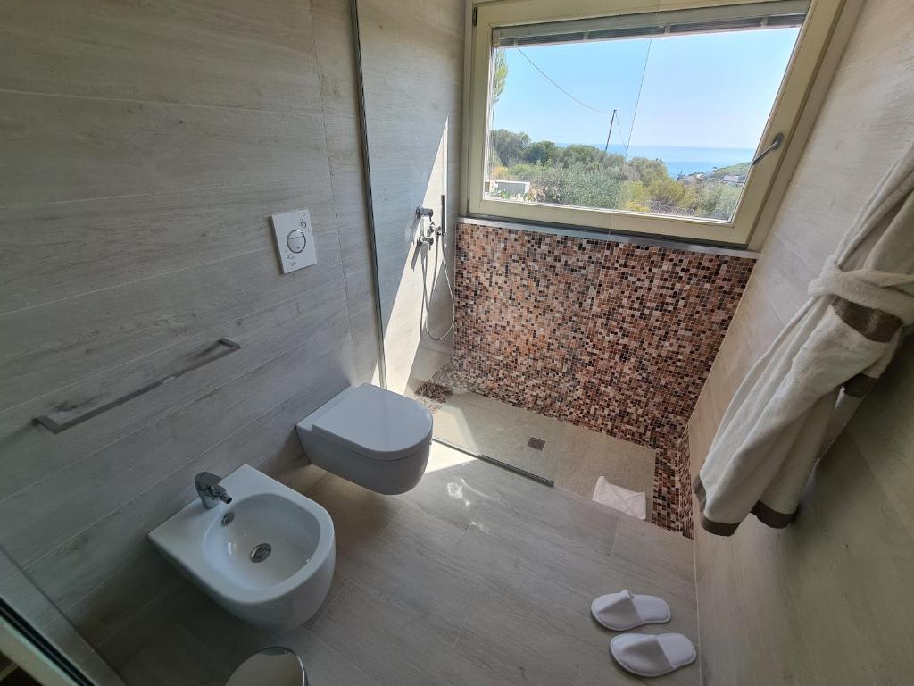 une salle de bain avec toilettes, lavabo et fenêtre dans l'établissement VILLA ROSA, à Peschici 9 autres photos
