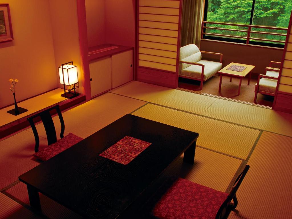 un salon avec une table et une chaise dans l'établissement Dai-ichi Takimotokan, à Noboribetsu