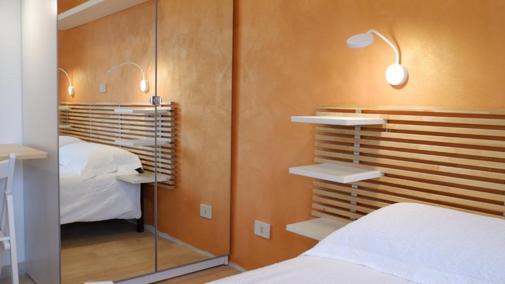 - une chambre avec deux lits et deux lumières sur le mur dans l'établissement Hotel Venezuela, à Lido di Jesolo