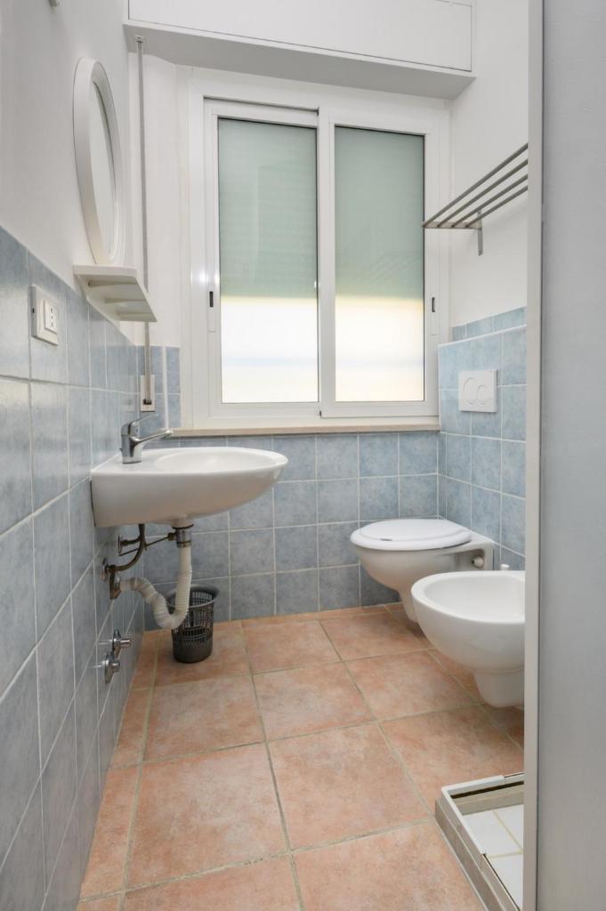 une salle de bain avec deux lavabos et un WC dans l'établissement Hotel Cà Vanni, à Rimini