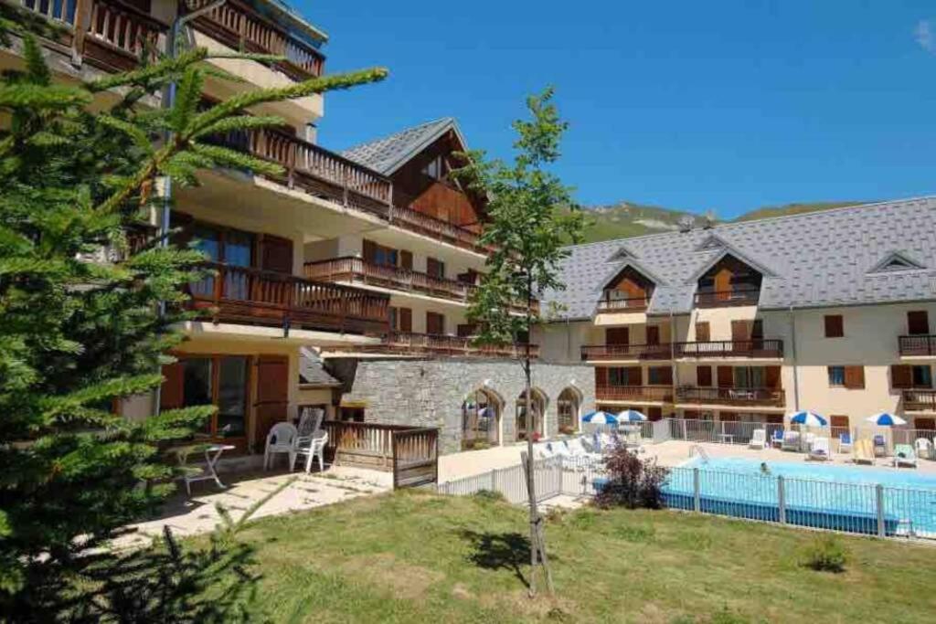 un grand immeuble avec piscine dans l'établissement Logement 4/6 personnes à la montagne avec piscine, à Saint-Sorlin-dʼArves