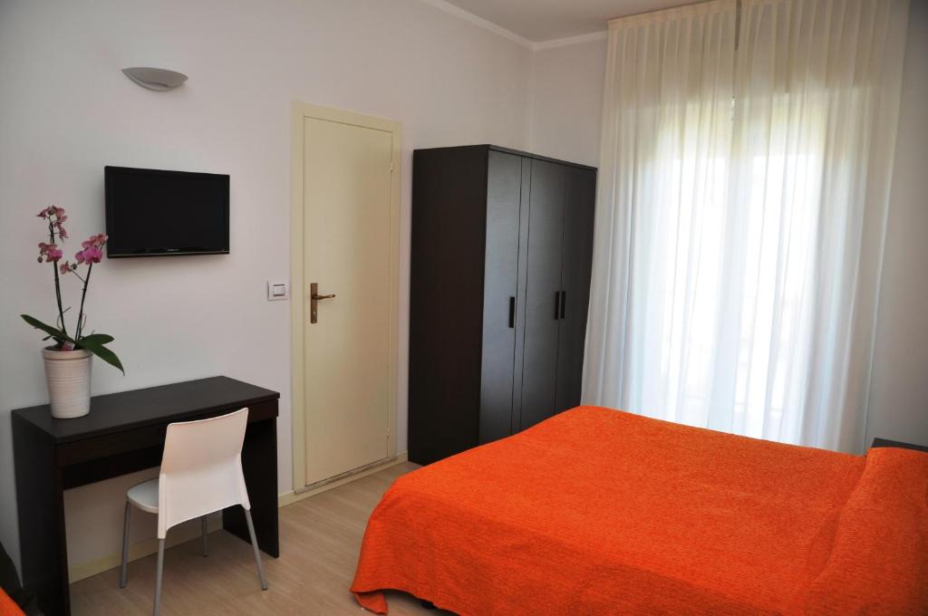 une chambre avec un lit, un bureau et une télévision dans l'établissement Hotel Lugano, à Riccione 26 autres photos