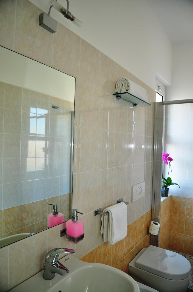 une salle de bain avec un lavabo, des toilettes et un miroir dans l'établissement Hotel Lugano, à Riccione
